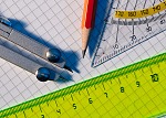 Zirkel, Bleistift, Geodreieck und Lineal auf kariertem Papier