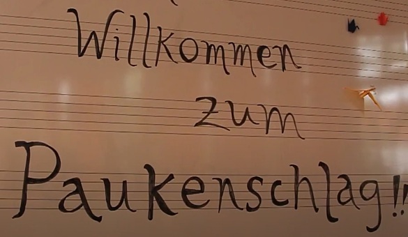 Schriftzug Paukenschlag auf einem Notenblatt