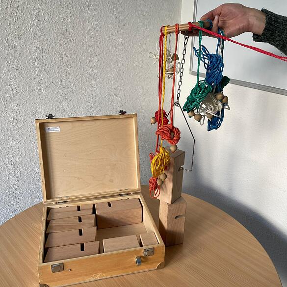 Inhalt des Tower-of-Power-Koffers bestehend aus Holzelementen und farbigen Schüren Inhalt des Tower-of-Power-Koffers bestehend aus Holzelementen und farbigen Schüren