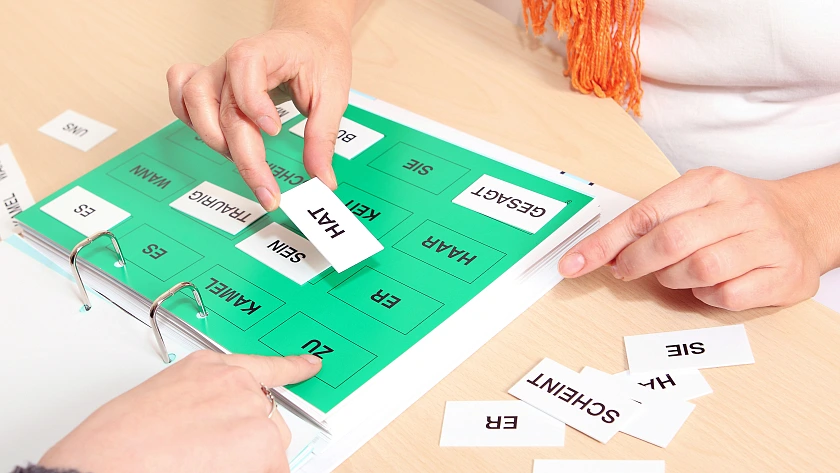 Zwei Personen, die mit Wortkärtchen eine Sprachlernübung machen.