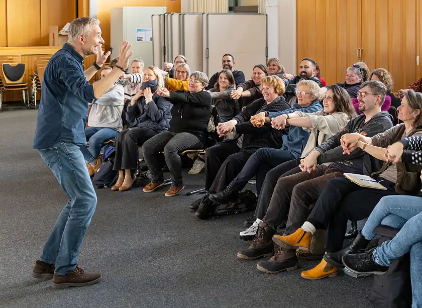 Felix Gaudo macht eine Lockerungsübung mit dem Publikum