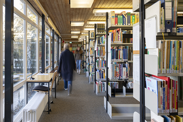 Frau geht durch die Bibliothek