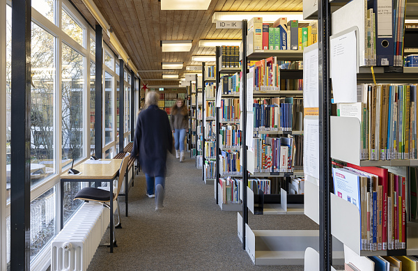 Zwei Frauen gehen durch die Bibliothek