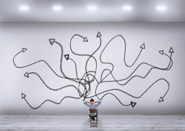 Mensch vor Wand mit Pfeilen