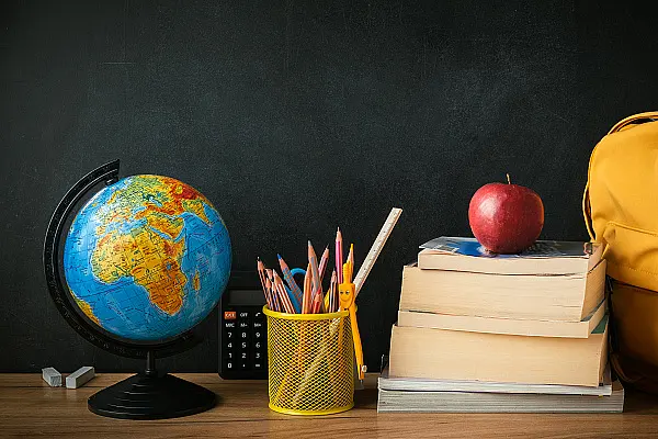 Stillleben mit Schulsymbolen. Globus, Hefte, Lineale