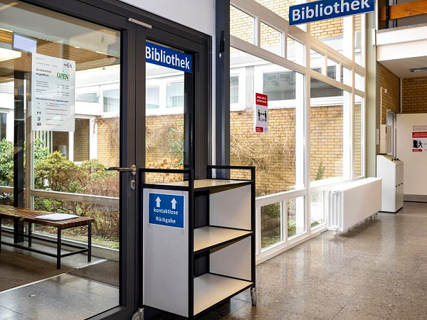 Eingang der Bibliothek mit dem Rückgabewagen