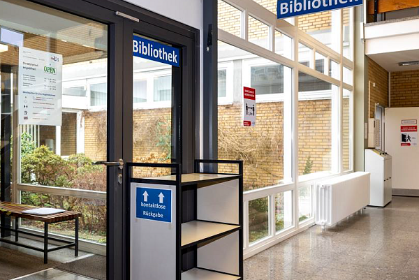 Eingang der Bibliothek mit dem Rückgabewagen