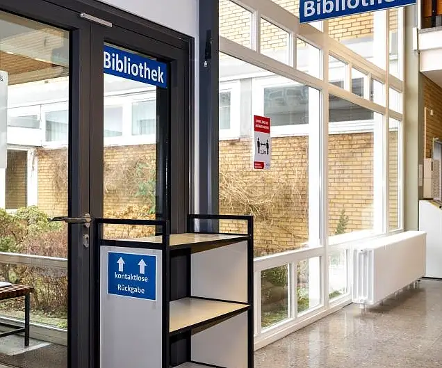 Eingang der Bibliothek mit dem Rückgabewagen