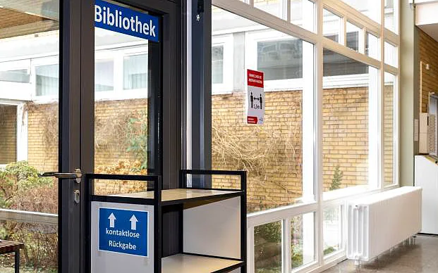Eingang der Bibliothek mit dem Rückgabewagen