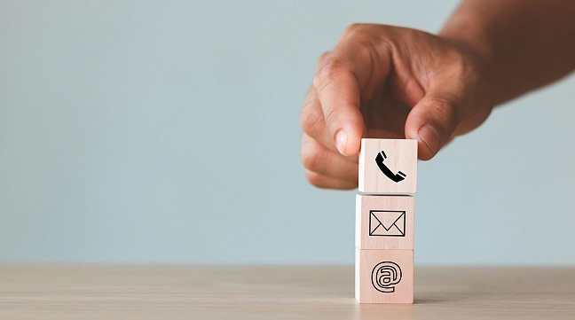 Hand ordnet Würfel mit Kontaktsymbolen