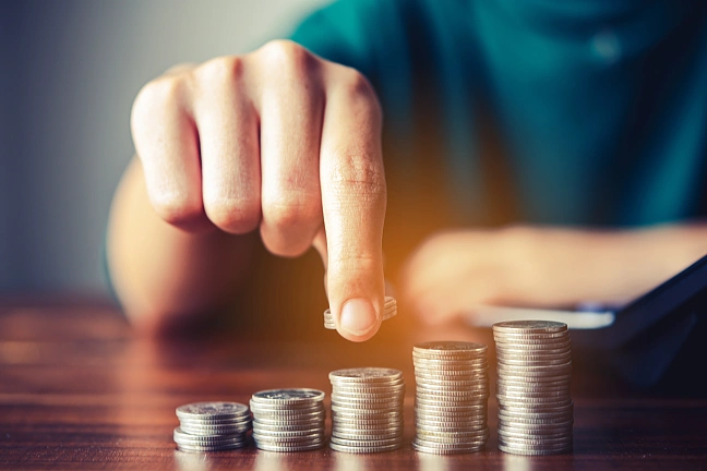 Hand einer Person macht Münzenstapel