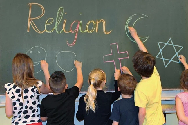 Kinder an Schultafel mit der Aufschrift Religion