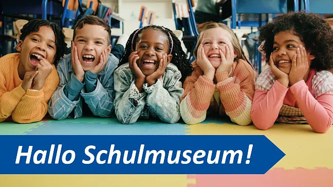 Schulkinder mit Aufschrift: Hallo Schulmuseum