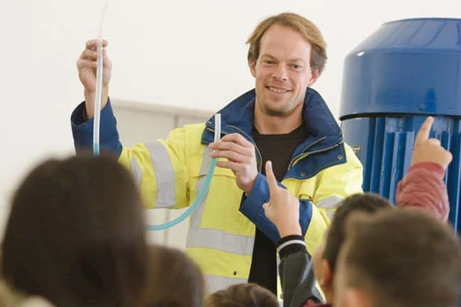 Lächelnder Mann steht vor Schulklasse