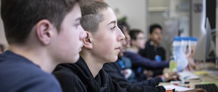 Schüler mit Boys'Day-Armbändern an Bildschirmarbeitsplätzen