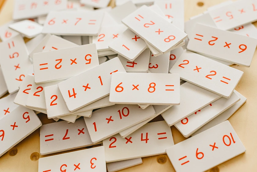 unsortiert hingeworfene Plättchen aus einem Rechen-Lernspiel