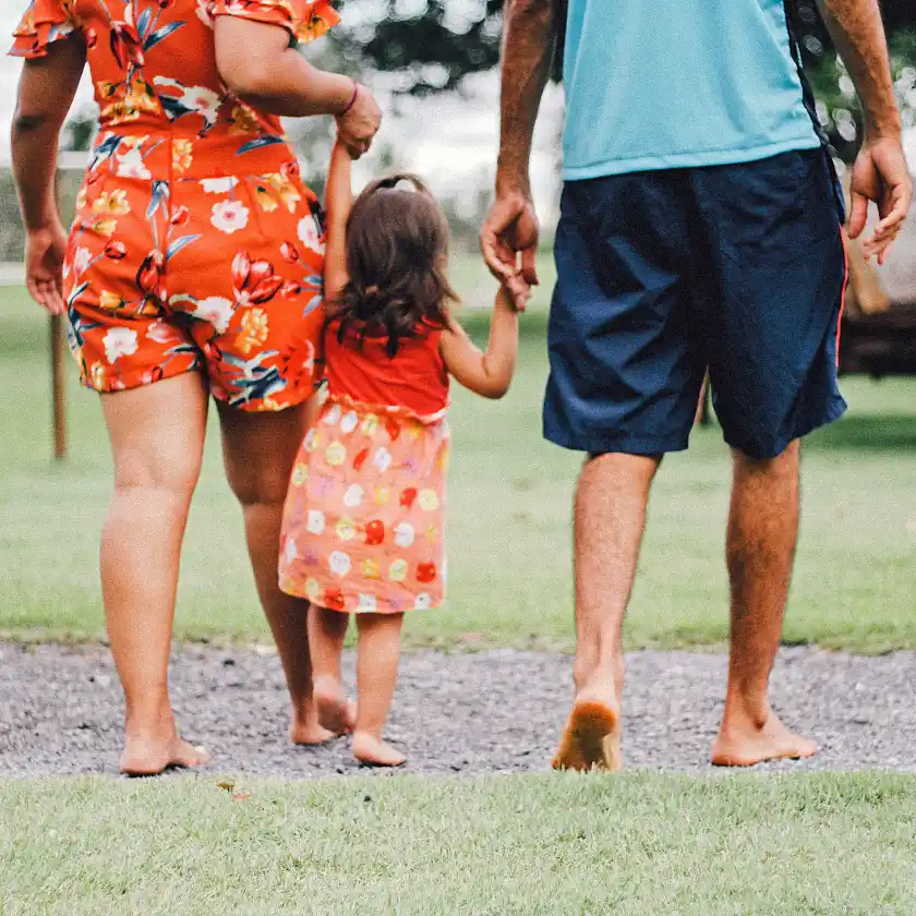 Eltern halten ihr Kind an den Händen