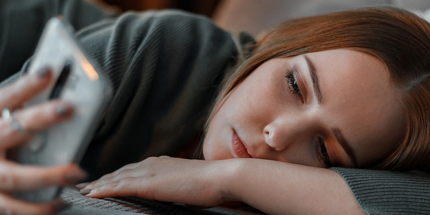 Mädchen schaut traurig auf Smartphone