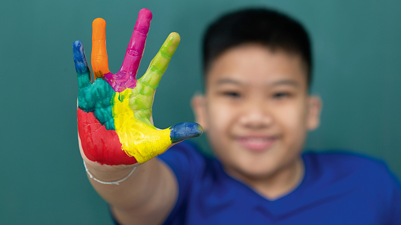 Junge mit bunt bemalten Händen und der Aufschrift Inklusives Wissen: Angebote online buchen